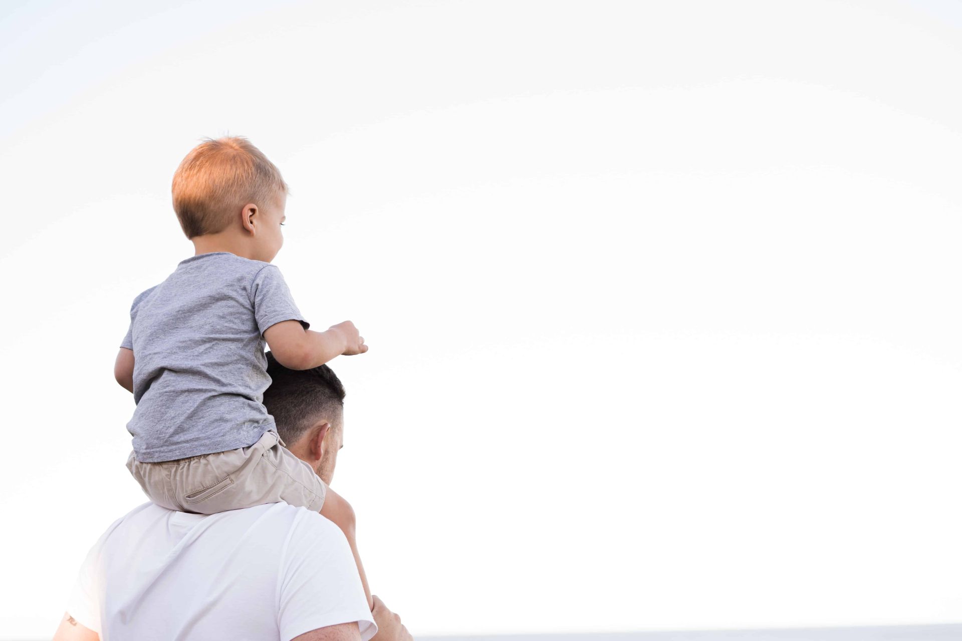 a man holding a child on his shoulders, representing a father and child