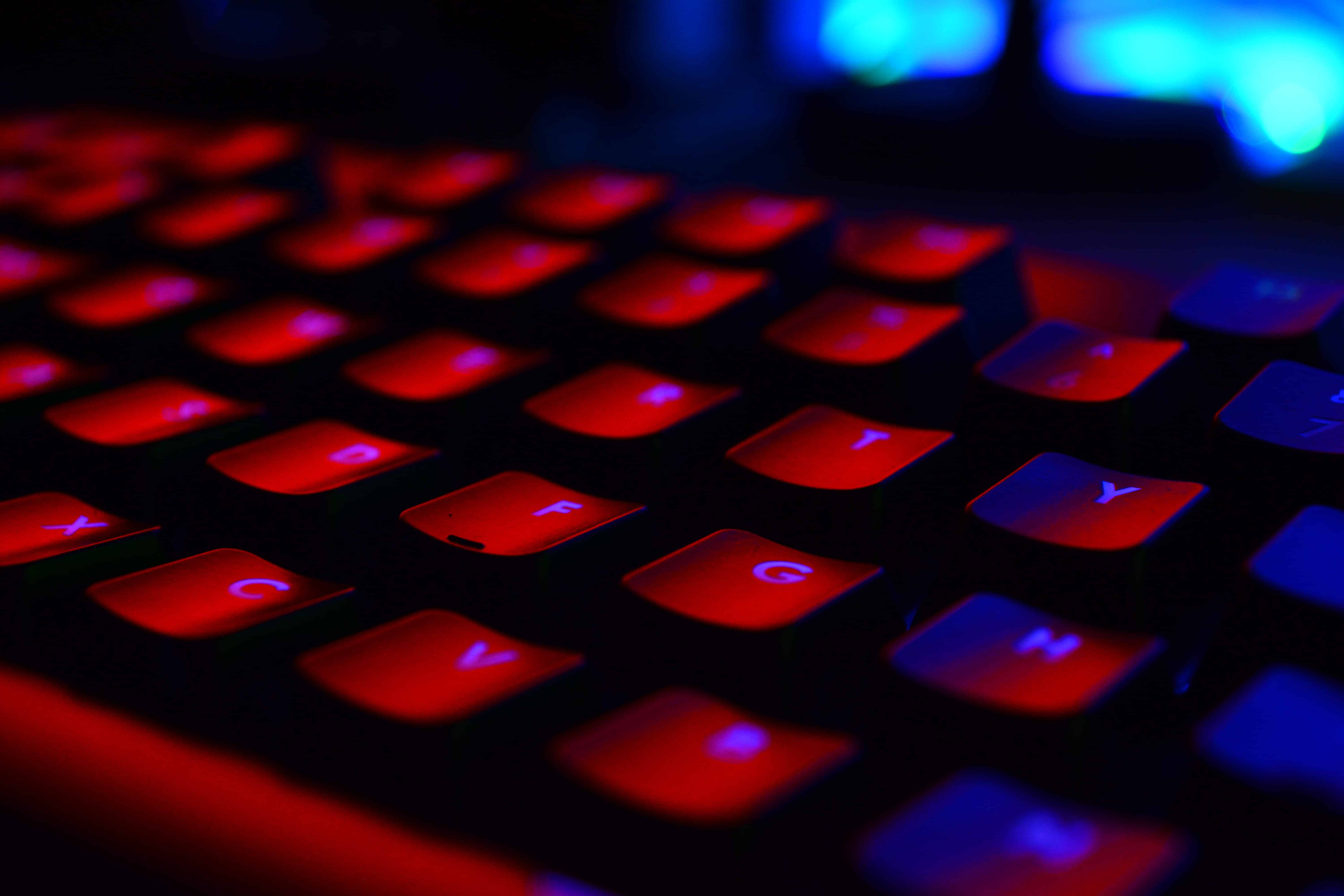 computer keyboard lit in red indicating using the internet for malicious purposes