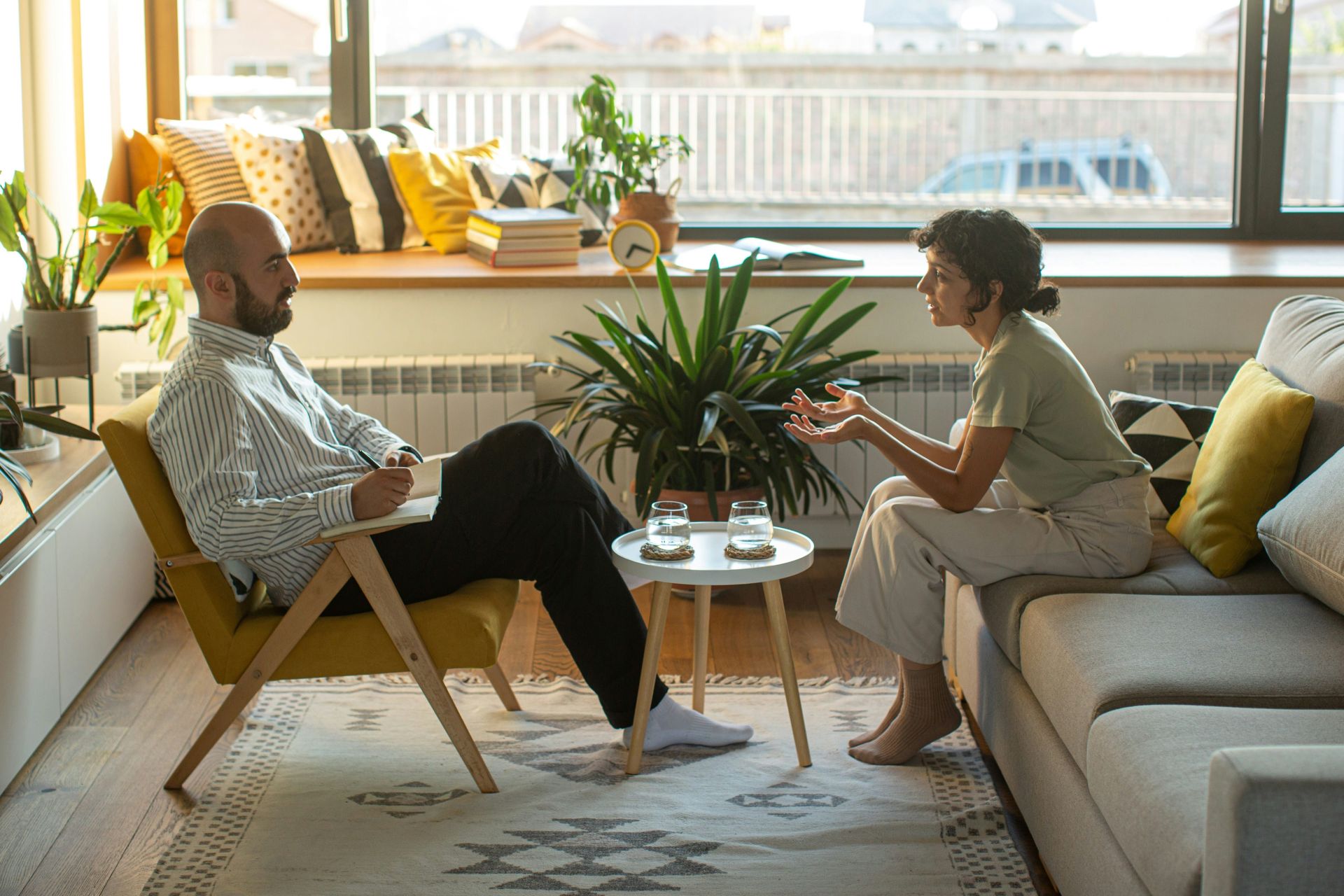 A male therapist sitting across a table from his female patient, representing mental health issues in Alberta family law